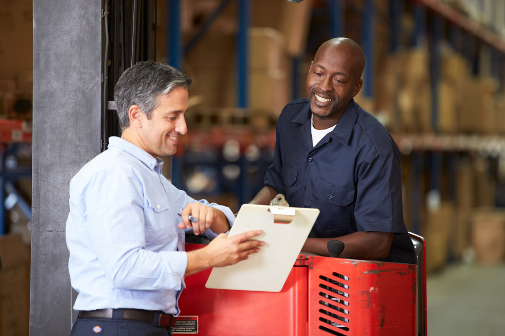 Employee With Clipboard Talking With A Smiling Employee